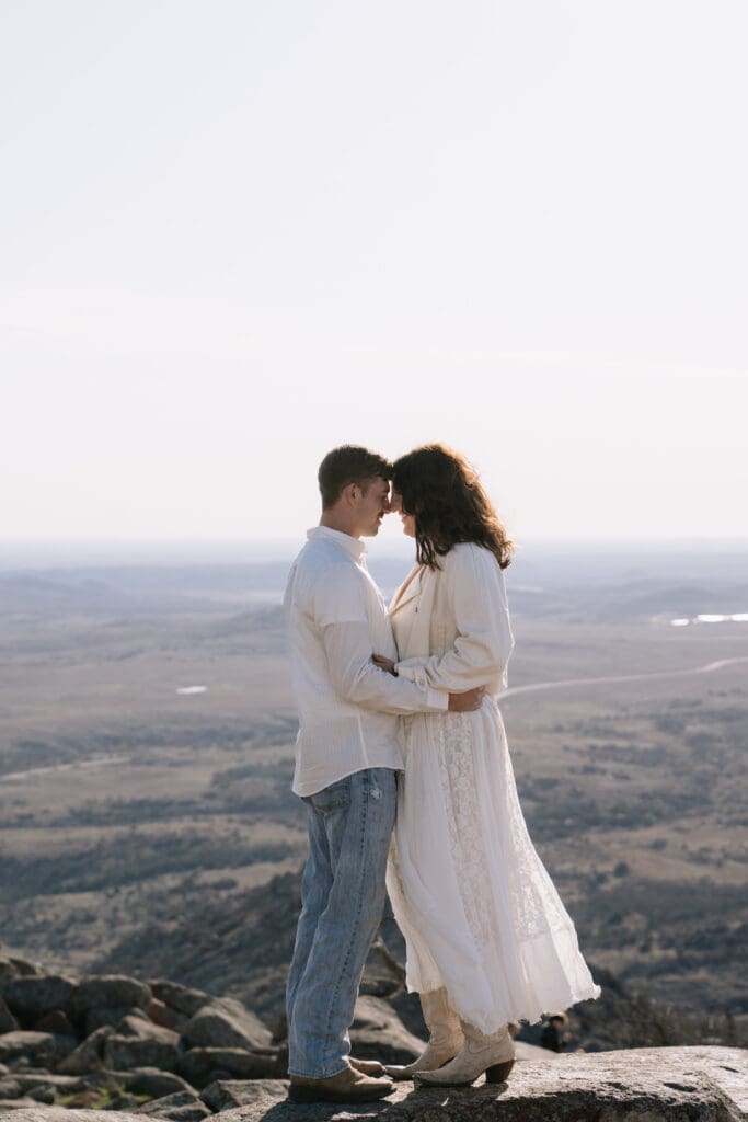Couple holding hands overlooking Mt. Scott summit at sunset
