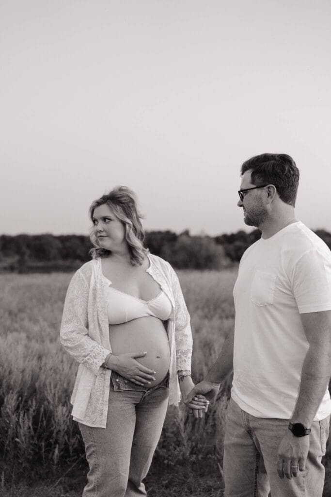 Expecting mother standing in a field during a maternity session near Austin