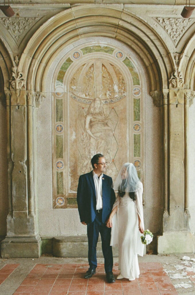Couple framed by tall trees in a romantic setting