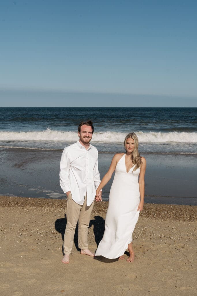Couple running together on the beach during a movement-focused engagement session