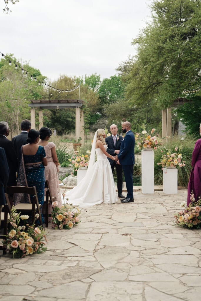 Bride holding a vibrant bouquet surrounded by blooming wildflowers in Austin