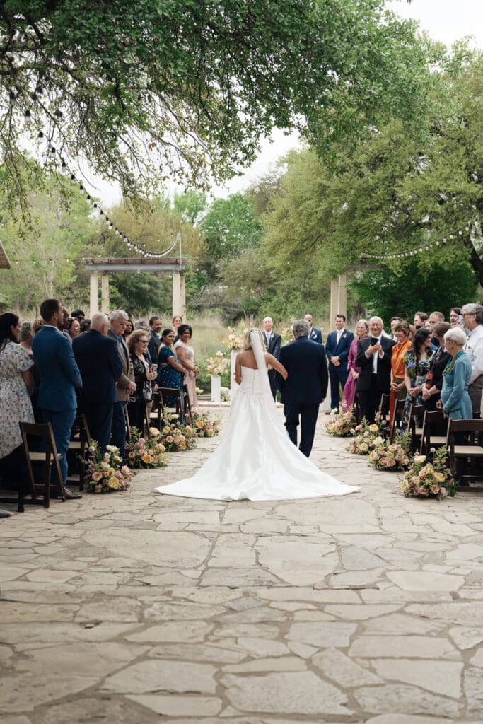 Bride and groom sharing a kiss along a garden path at Lady Bird Wildflower Center